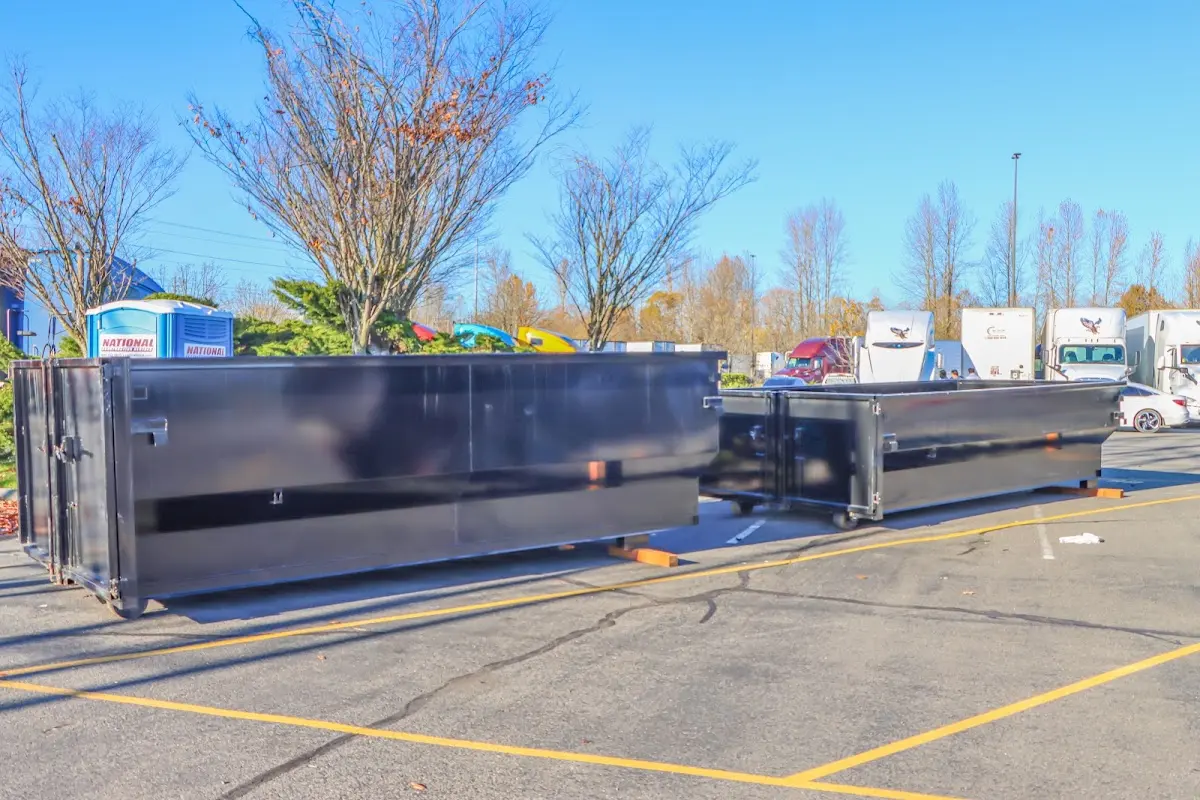 Professional dumpster rental service with roll-off container on residential driveway in Corinth